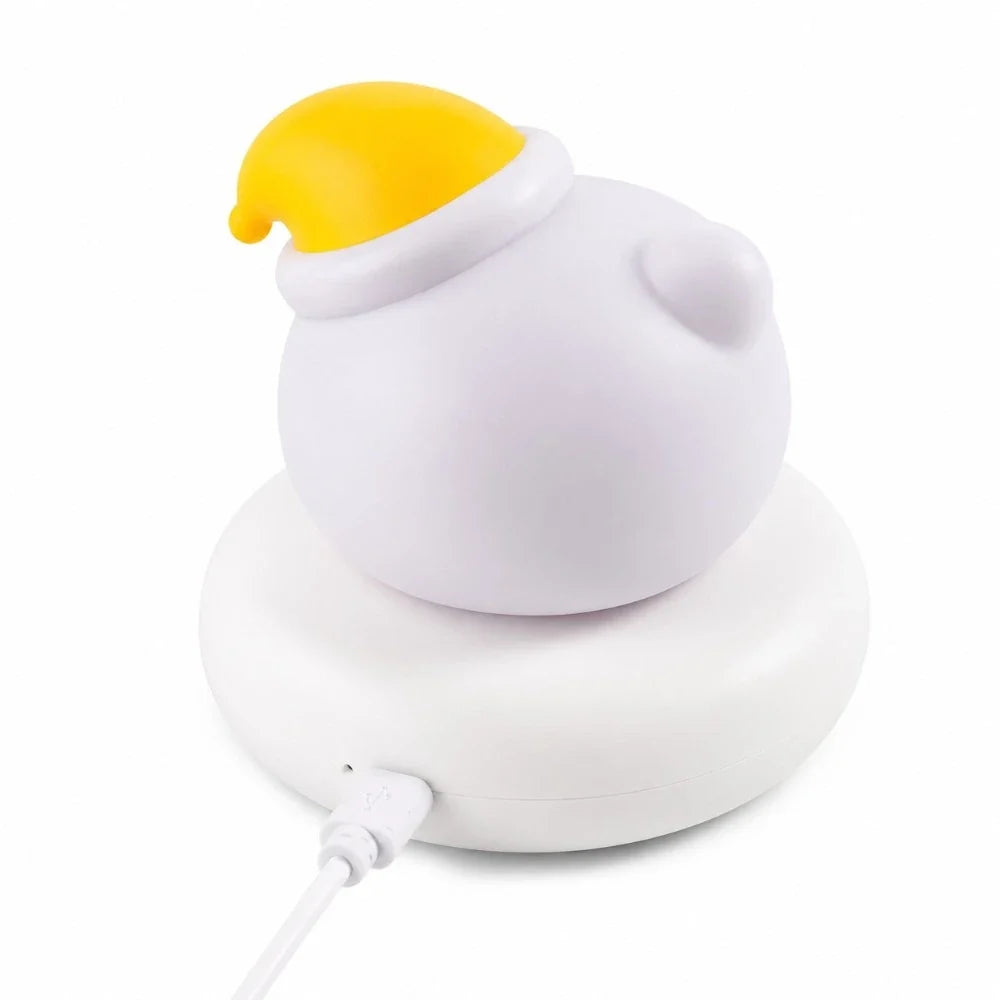 Veilleuse LED ours Bouba blanche avec bonnet jaune, vue de dos avec câble USB branché sur le socle