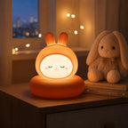 Veilleuse LED lapin Luco diffusant une lumière douce dans une chambre d'enfant, avec une peluche en arrière-plan.