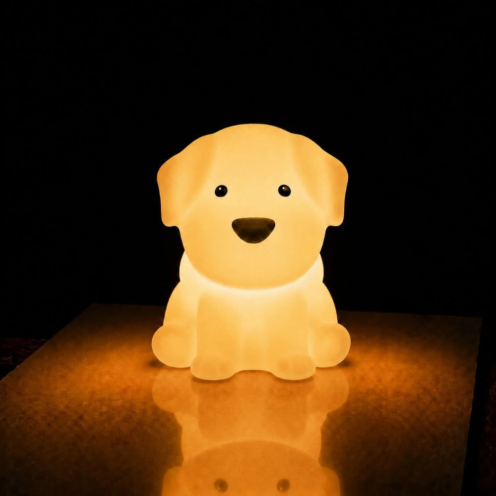 Veilleuse LED chiot Milo allumée diffusant une lumière chaude avec reflet sur la table