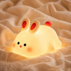 Veilleuse LED lapin Tibo posée sur une couverture d'enfant