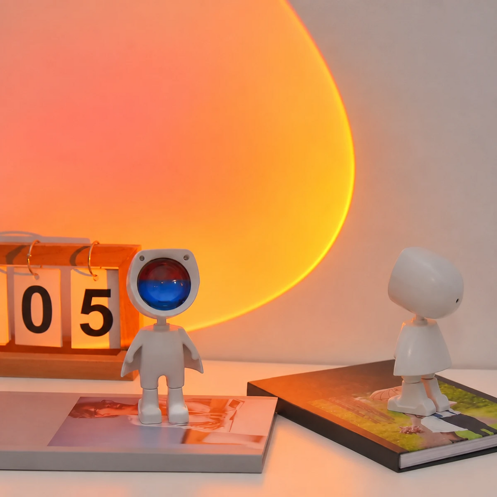 Veilleuse projecteur Iris posée sur un bureau, halo coucher de soleil projeté au mur