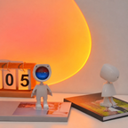 Veilleuse projecteur Iris posée sur un bureau, halo coucher de soleil projeté au mur