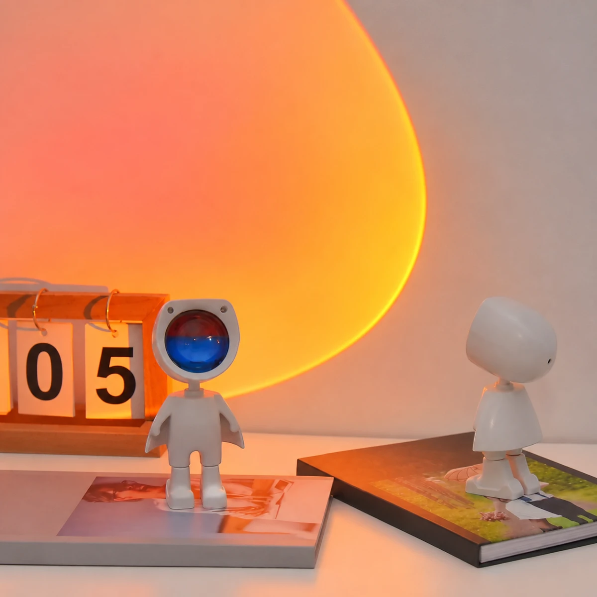 Veilleuse projecteur Iris posée sur un bureau, halo coucher de soleil projeté au mur