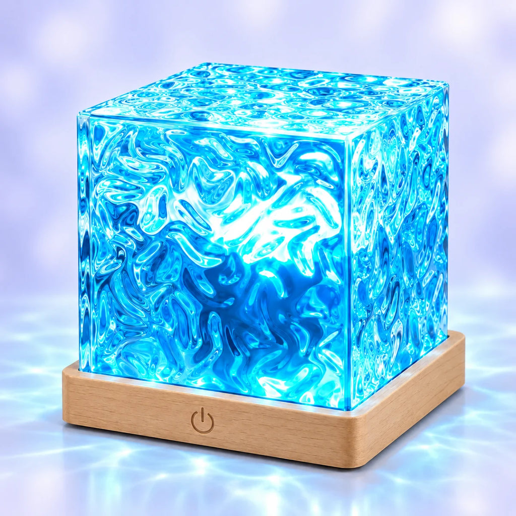 Veilleuse projecteur Aqua allumée en bleu, cube en acrylique texturé effet vagues sur socle effet bois, fond bleuté apaisant
