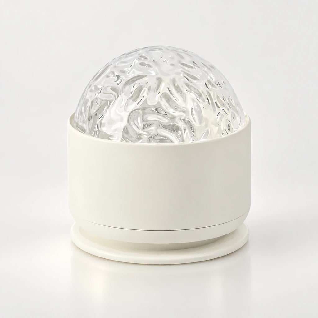 Veilleuse projecteur Marina, dôme texturé transparent sur socle blanc arrondi, sur fond clair
