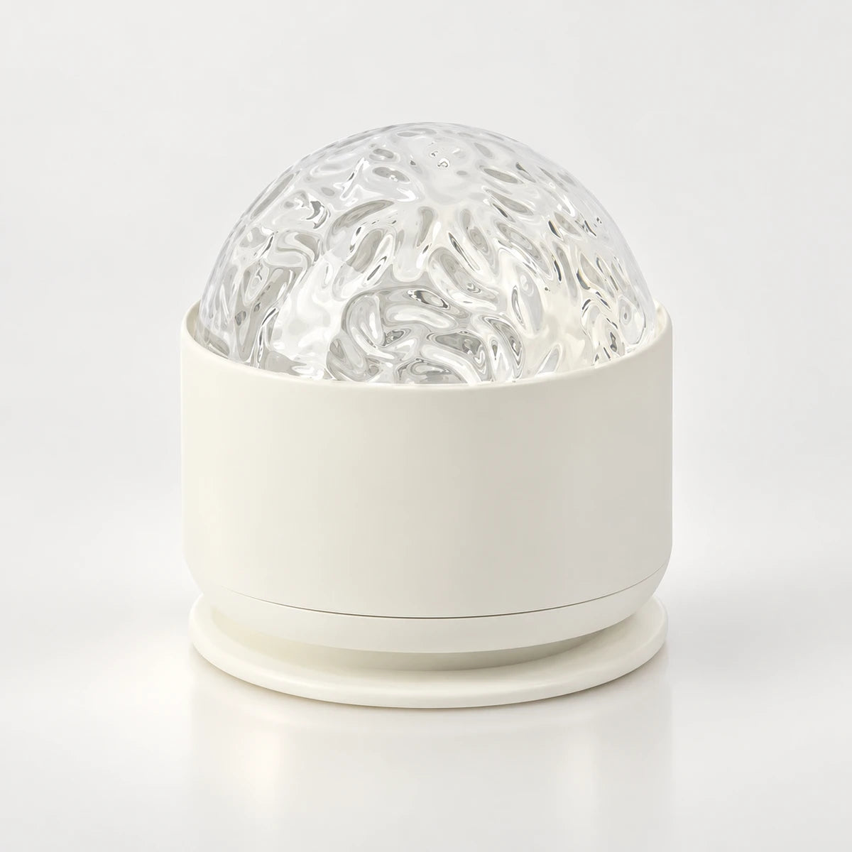 Veilleuse projecteur Marina, dôme texturé transparent sur socle blanc arrondi, sur fond clair
