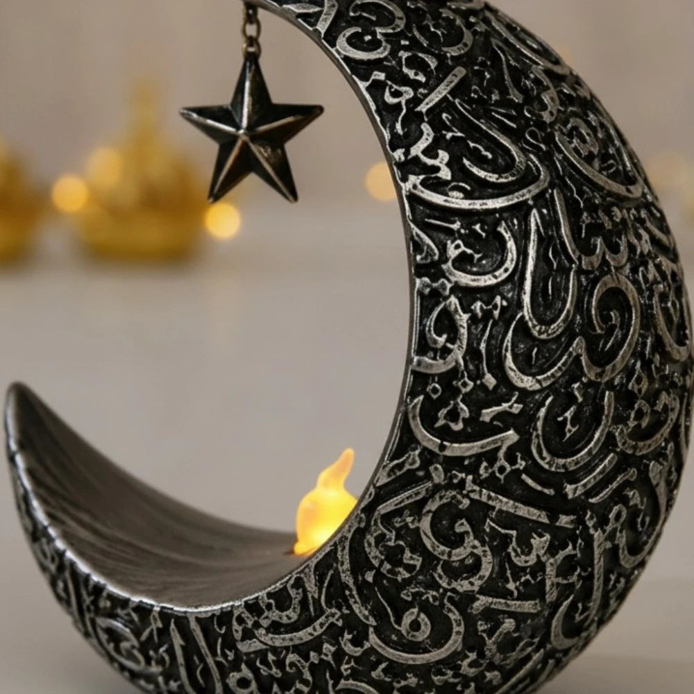 Vue 3/4 arrière zoomée veilleuse LED croissant de lune argentée, gravures calligraphie arabe en relief, étoile suspendue et flamme LED, fond bokeh doré